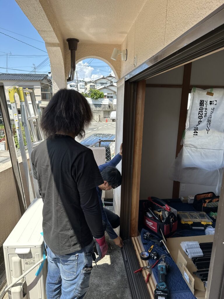カバー工法で玄関まわりを工事するマドアーズ！のスタッフ2名