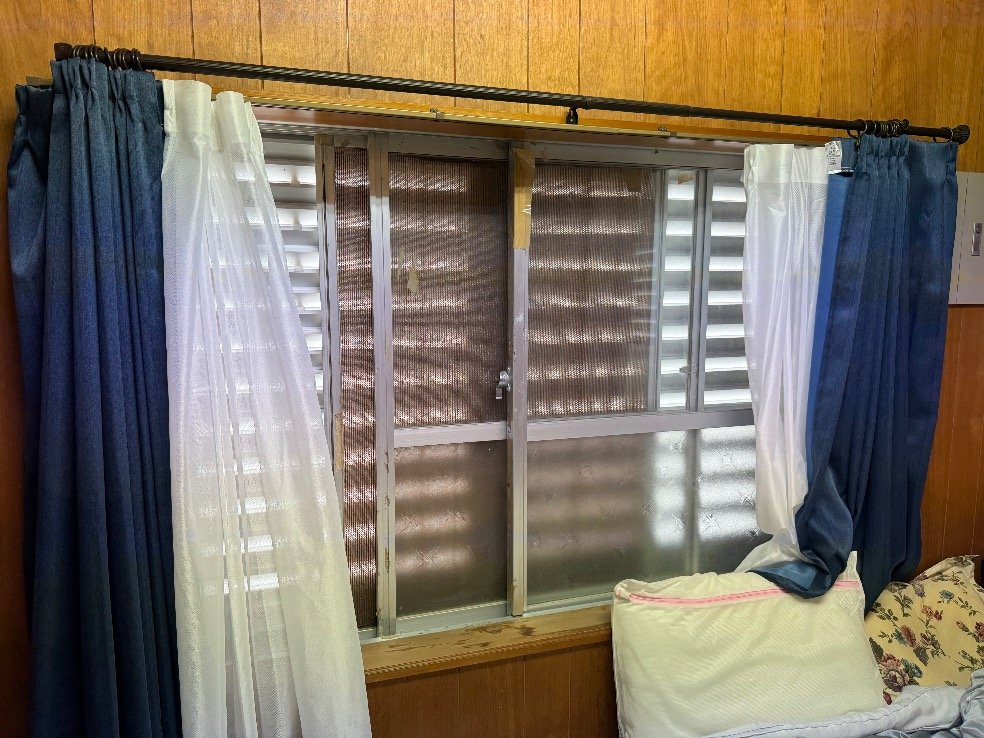 窓の外側にルーバー型の雨戸が付いた部屋の窓